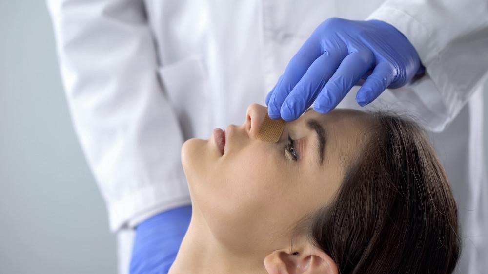 Woman having nose examined