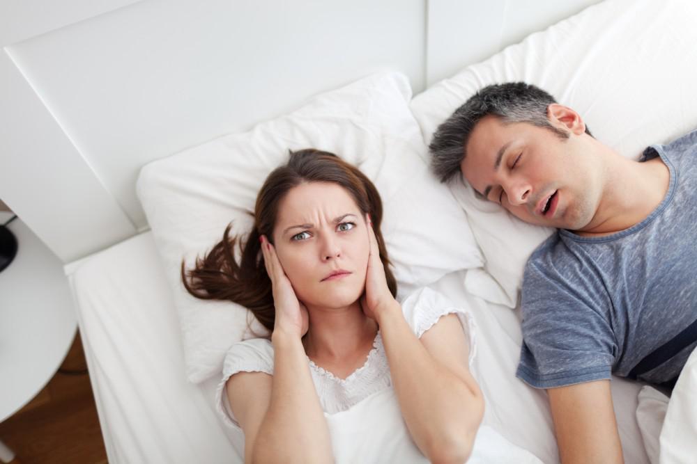 Woman annoyed by mans snoring