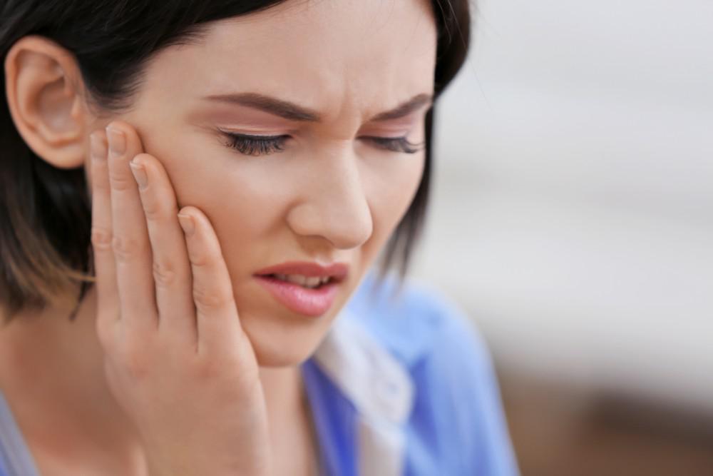 Woman experiencing jaw pain