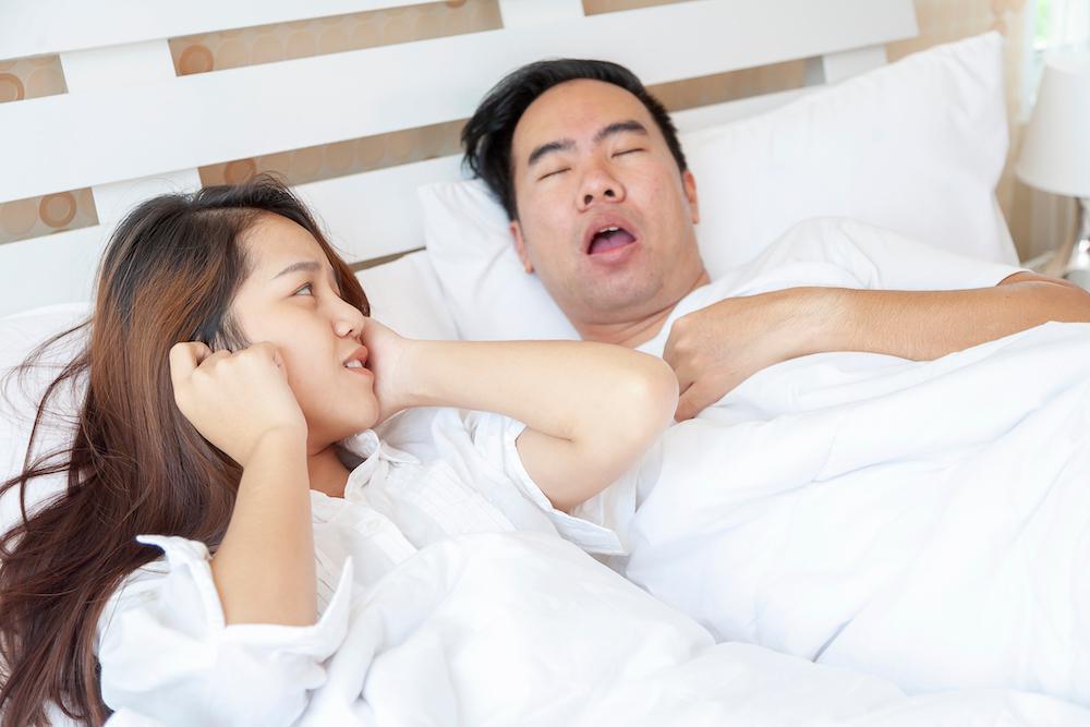 Woman annoyed by mans snoring